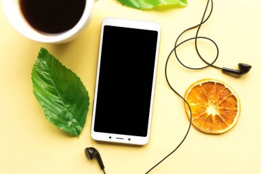 Sarı arka planda kahve fincanı ve Mobile Mobile. Üst Manzara. Asgari konsept