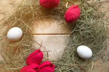 Ahşap zemin üzerinde yumurta ve lale olan saman yuvası. Metin için alanı kopyala. Paskalya konsepti