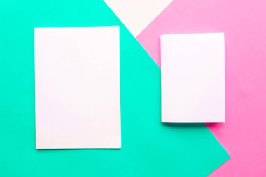 Geometrik yeşil, pembe ve beyaz arka planda iki beyaz model boş. Metin için alanı kopyala. Asgari konsept