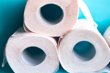 Mavi arka planda yumuşak, beyaz tuvalet kağıdı ruloları