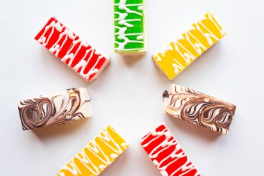 Beyaz arkaplanda parlak renkli pastaların yuvarlak çerçevesi, üst görünüm