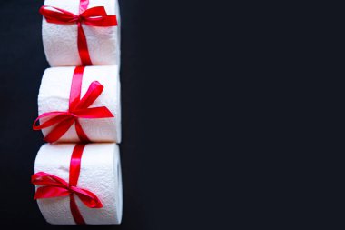 Hediyeye sarılı tuvalet kağıtları parlak siyah arka planda. Covid19 konsepti