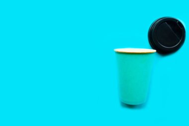 Mavi arka plandaki kahve fincanını kaldır, asgari konsept. Metin için alanı kopyala