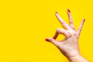 Kadının eli parlak sarı arka planda iyi bir jest gösteriyor. Minimum konsept. Metin için alanı kopyala