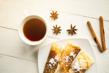 Lezzetli gözleme ruloları, çay fincanı ve ahşap masa. Üst Manzara. Karantina konsepti