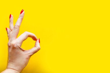 Kadının eli parlak sarı arka planda iyi bir jest gösteriyor. Minimum konsept. Metin için alanı kopyala