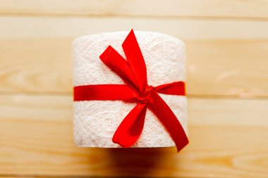 Tuvalet kağıdı, tahta arka planda hediye yayı ile sarılmış. Covid19 konsepti