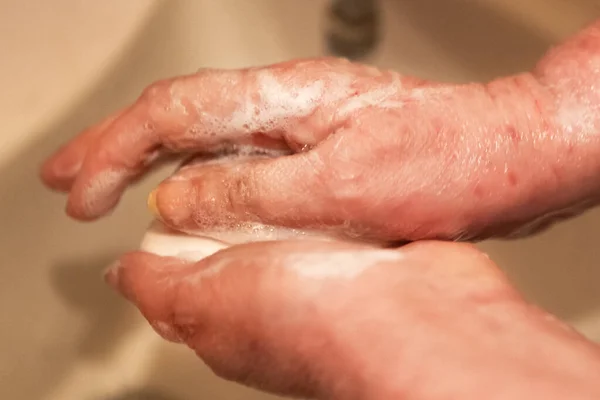 Woman washes her hands under a stream of soap and water. Covid19 concept