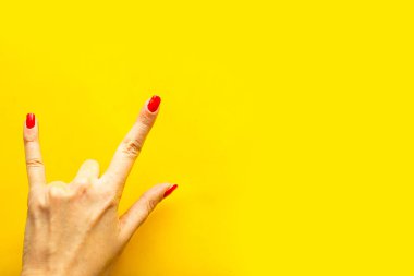 Kadın eli, parlak sarı arka planda bir hareket sergiliyor. Metin için alanı kopyala