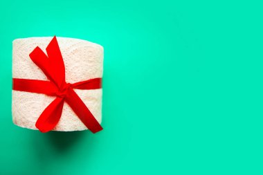 Hediyeye sarılı tuvalet kağıdı parlak yeşil arka planda. Covid19 konsepti. Metin için alanı kopyala
