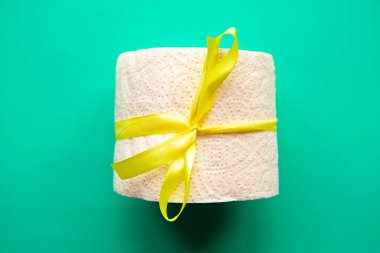 Hediyeye sarılı tuvalet kağıdı parlak yeşil arka planda. Covid19 konsepti. 