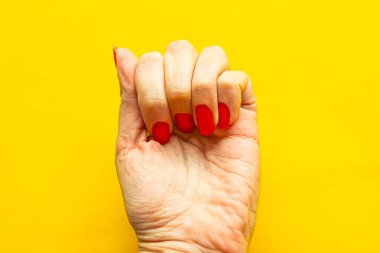 Sarı arka planda kadın yumruğu