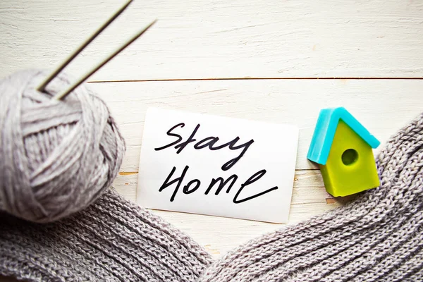 knitting and toy house on wooden background. Stay Home concept
