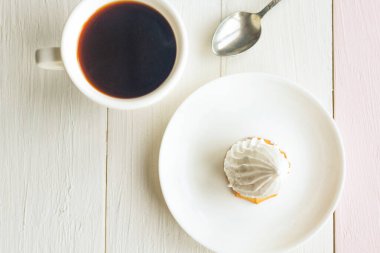 Düz fotograf, kahve fincanı ve kek, ahşap arka planda.. 