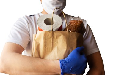 Koruyucu maskeli ve tıbbi eldivenli teslimatçı paket yemek getiriyor. Karantina döneminde yiyecek teslimatı. Covid-19 konsepti