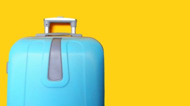 Mavi bavul sarıda izole edilmiş. Seyahat konsepti, afiş. Metin için alanı kopyala