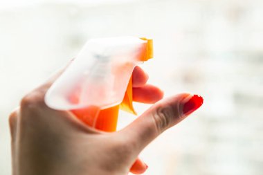 Kadın pencereyi bir aletle temizliyor, yakın plan.