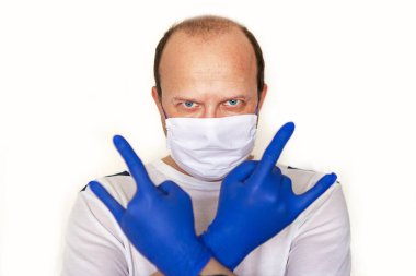 Tıbbi eldivenli ve maskeli bir adam kaya işaretini gösteriyor. Covid-19 konsepti