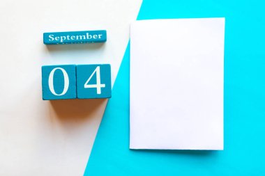 4 Eylül. Ahşap el yapımı takvim ve geometrik beyaz ve mavi arkaplan üzerinde beyaz model boş