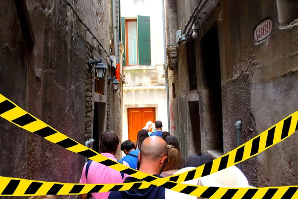 Tourists walking down Italian streets. Barrier tape - quarantine, isolation, entry ban. Covid-19 concept.