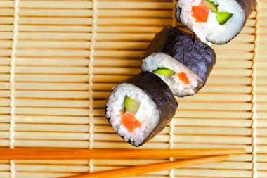 Suşi, suşi hasırında yuvarlanır. Üst görünüm, metin için boşluk kopyala