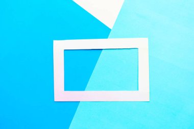 Geometrik mavi arkaplanda beyaz fotoğraf çerçevesi. Boşluk için alanı kopyala. Asgari konsept