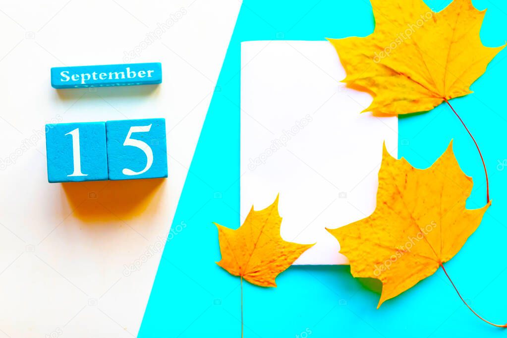 September 15. Wooden handmade calendar and white mockup blank with dry maple leaves on geometric white and blue background