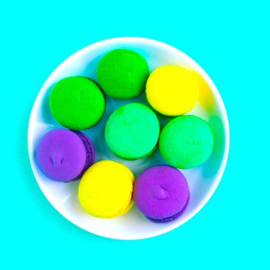 Tabaktaki güzel renkte badem kurabiyeleri, yeşil arka plan. Düz yatış, üst görünüm