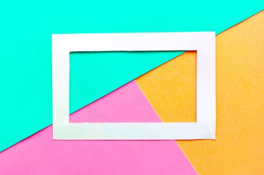 Geometrik renkli pastel arkaplanda beyaz fotoğraf çerçevesi. Metin için alanı kopyala. Tasarım konsepti