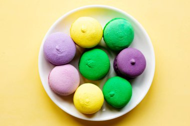 Tabakta tatlı renkli badem kurabiyeleri var. Düz yatış, üst görünüm