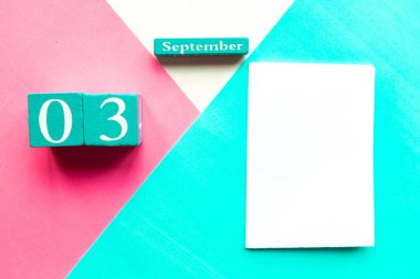 3 Eylül. Ahşap el yapımı takvim ve geometrik beyaz, pembe ve mavi arka planda beyaz maket.