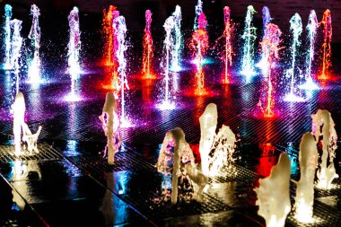 Gece caddesindeki parlak ve renkli çeşme.