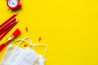 Okul gereçleri ve üzerinde açık sarı arka planda 