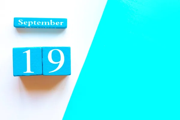 19 Eylül, boş mavi ve beyaz geometrik arkaplan. Ahşap el yapımı takvim