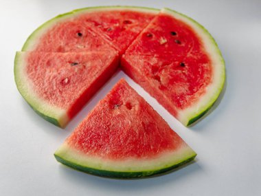 Taze kırmızı lezzetli karpuz dilimleri renkli bir arka plan üzerinde bir daire içinde ortaya konur.