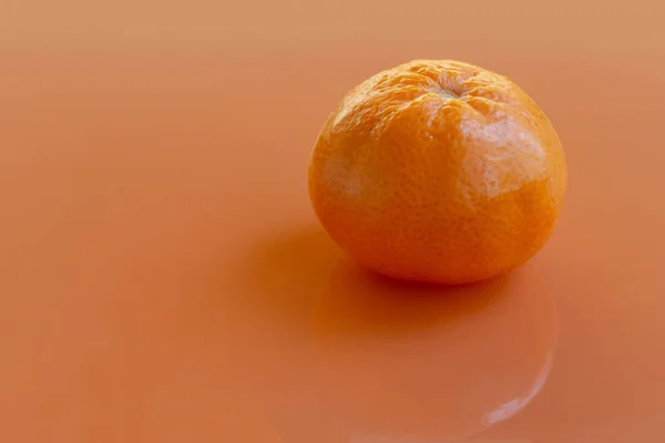 Mandarina sobre fondo naranja — Foto de Stock