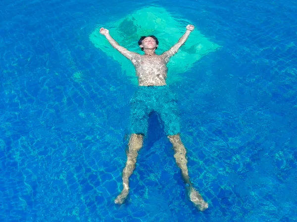 Νεαροί άνδρες με κοντό κολύμπι στέκονται στην άκρη μιας πισίνας απείρου κατά τη διάρκεια των διακοπών τους στη Σαντορίνη Ελλάδα — Φωτογραφία Αρχείου