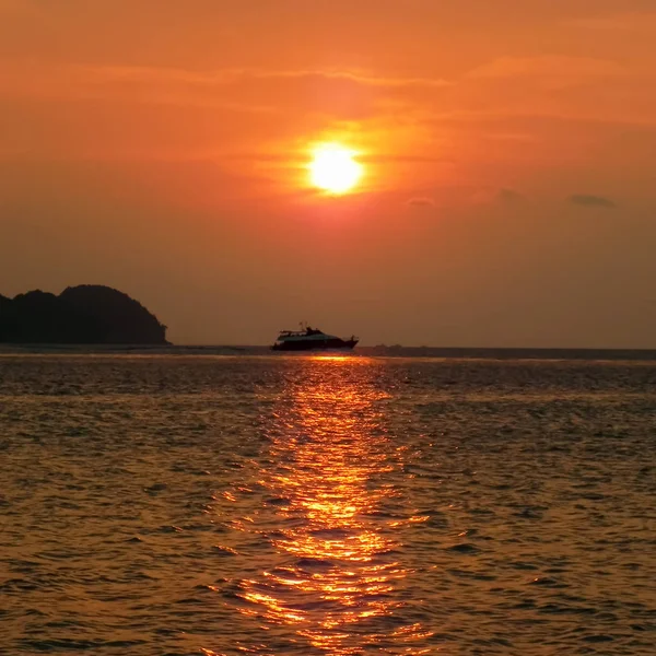 Barco de pesca en el mar en el horizonte durante la puesta del sol — Foto de Stock