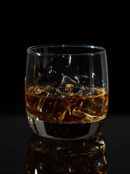 Whisky éclaboussure en verre avec glace sur un fond sombre — Photo