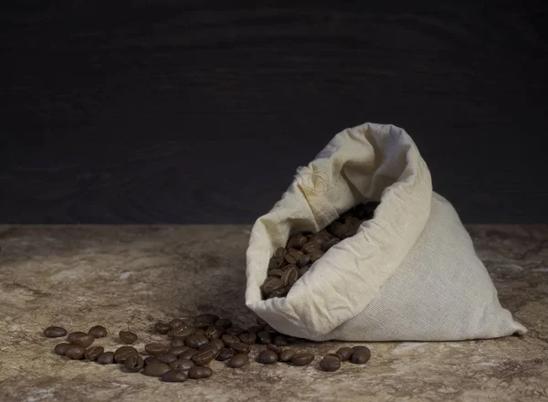 coffee beans in a bag on a wooden background.