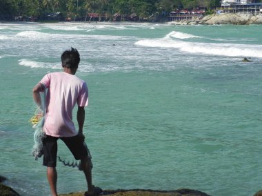 Balıkçı sabah güneş doğarken denize bir ağ attı.