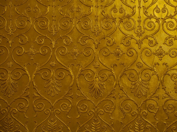 Old golden ornament on the wall.