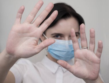 Maskeli kadın durdurma hareketi yapıyor. Coronavirüs veya covid 19 salgını konseptini durdur