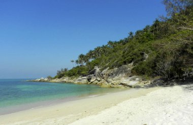 Gök mavisi kayalıkları ve Koh Phangan 'da yeşil ormanları olan güzel bir sahil. Tayland