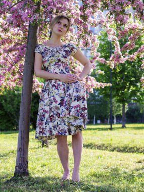 Çiçek açan bahçedeki güzel sarışın kadın. Gelin.