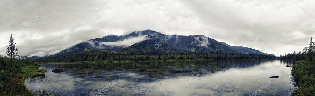Panarama Mountain summer landscape with a lake of water from melted snow. Khibiny or Khibiny tundra on the Kola Peninsula, in Russia, beyond the Arctic Circle.