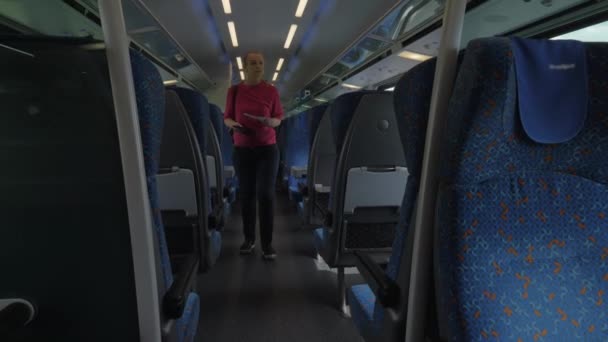 Shot of young blond woman going along train and searching her seat place, modern rail train, Vienna, Austria — Stock Video