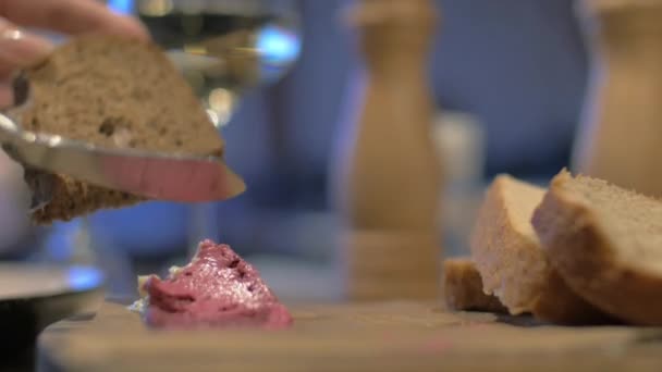 Vista cercana de la mesa de comida cuando la mano de la mujer extendiendo paté en pan integral — Vídeo de stock