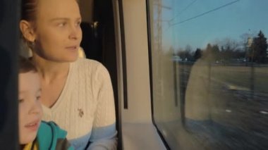 Demiryolu tren yerlerini penceresinde karşı oturma ve dışında izlerken anne ile küçük çocuk