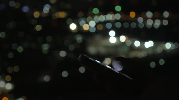 Primer plano de la mujer leyendo desde los teléfonos celulares en el fondo bokeh — Vídeos de Stock